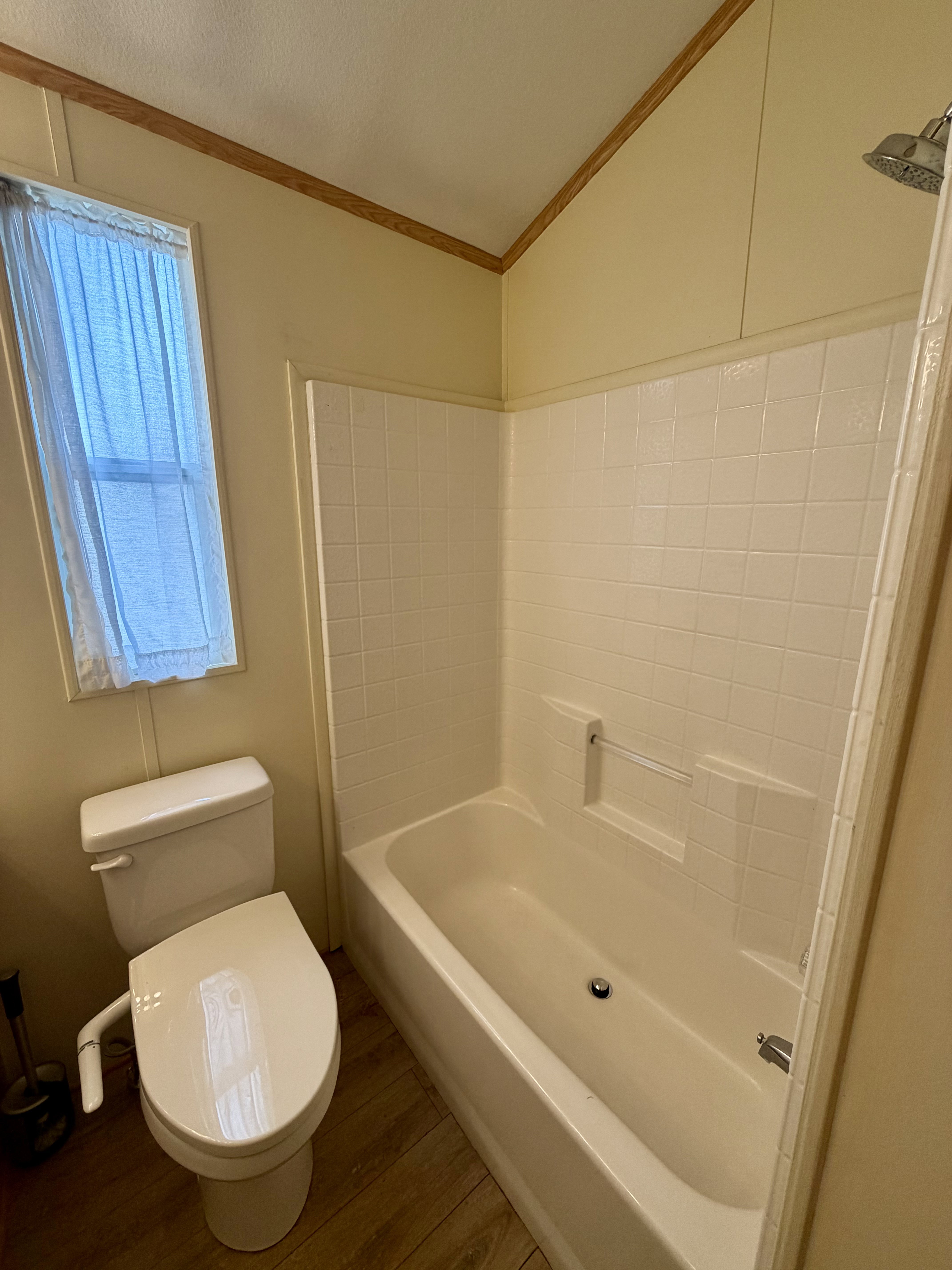 Full bathroom featuring wood finished floors, shower / bathtub combination, and crown molding