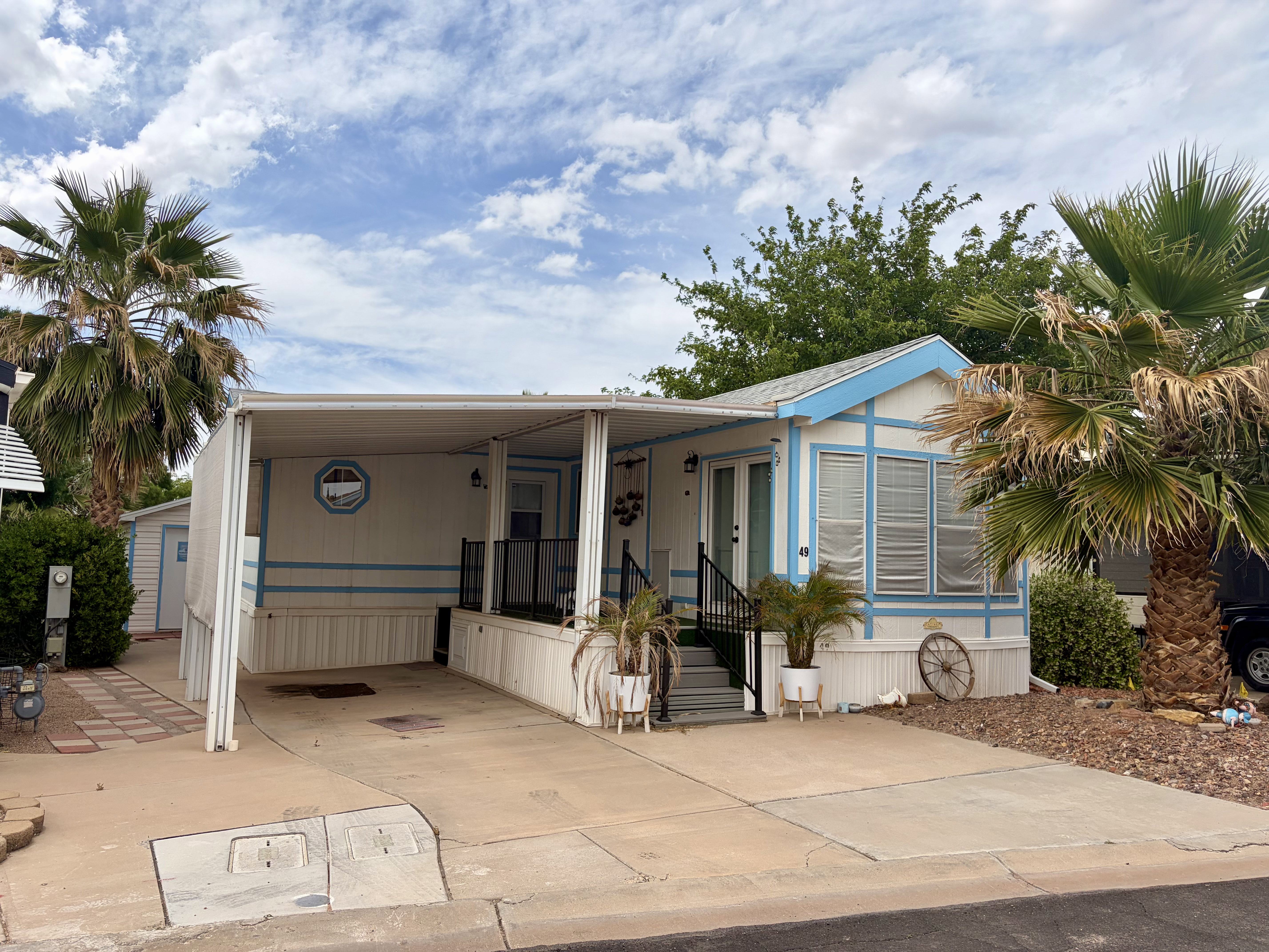 Manufactured / mobile home with an attached carport, covered porch, and concrete driveway