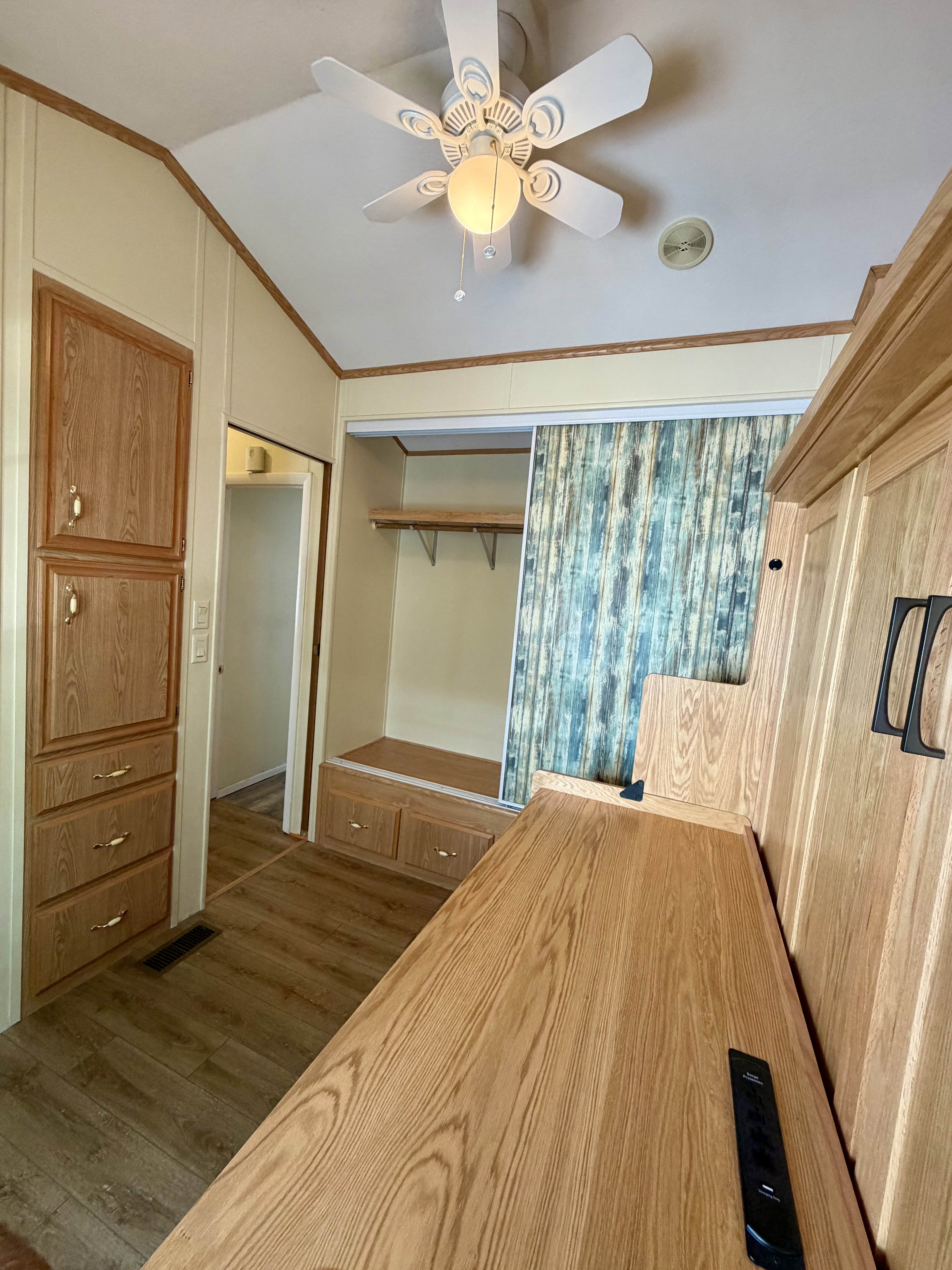 Unfurnished bedroom with ornamental molding, dark wood-type flooring, vaulted ceiling, and a ceiling fan