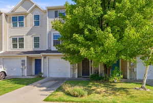 View of front facade with driveway, a front lawn, and an attached garage