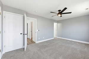 Unfurnished bedroom featuring light carpet and ceiling fan