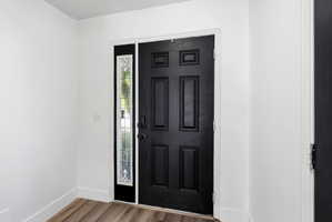 Entryway with wood finished floors and baseboards