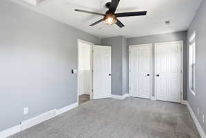 Unfurnished bedroom with carpet floors and a ceiling fan