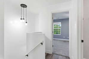 Hallway featuring an upstairs landing and wood finished floors