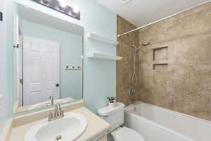 Bathroom featuring vanity, bathtub / shower combination, and a textured ceiling