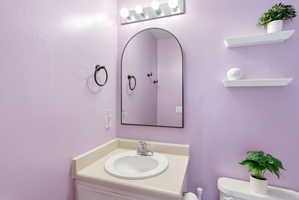 Half bathroom with vanity and toilet