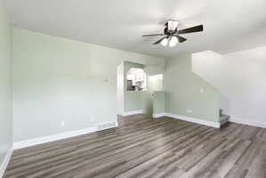 Bonus room with dark wood-style flooring and a ceiling fan