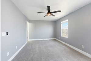 Empty room with light carpet and a ceiling fan