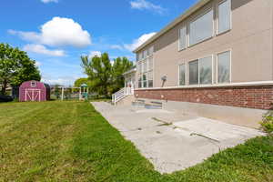 View of grassy yard featuring a shed