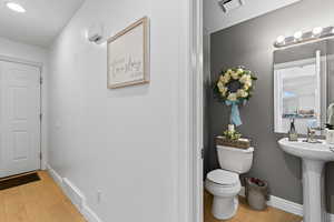 Bathroom with toilet and light wood finished floors