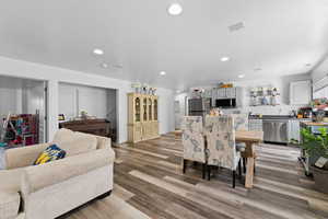 Living area with light wood-style flooring and recessed lighting