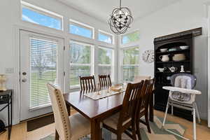 Dining area with light wood-style floors, a chandelier, and healthy amount of natural light