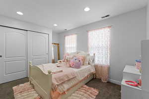 Bedroom featuring dark colored carpet, a closet, and recessed lighting
