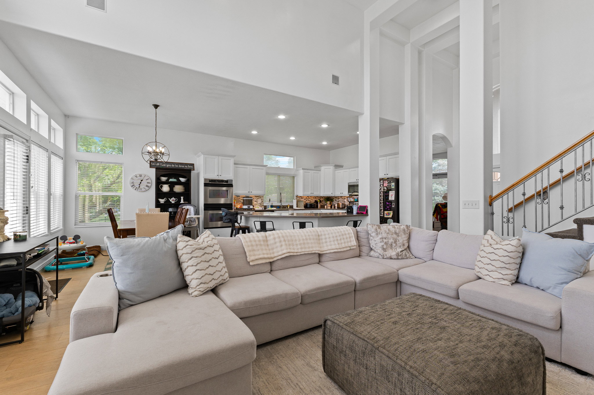 Living area with a chandelier, healthy amount of natural light, a high ceiling, and light wood finished floors
