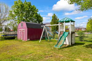 View of jungle gym featuring a trampoline and a storage shed