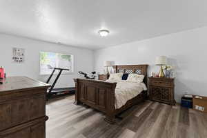 Bedroom with dark wood-type flooring and baseboards
