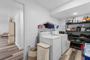 Laundry room featuring light wood finished floors and washing machine and clothes dryer