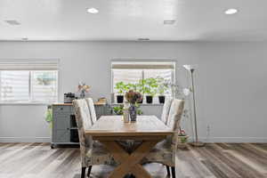 Dining room with light wood-style flooring and recessed lighting