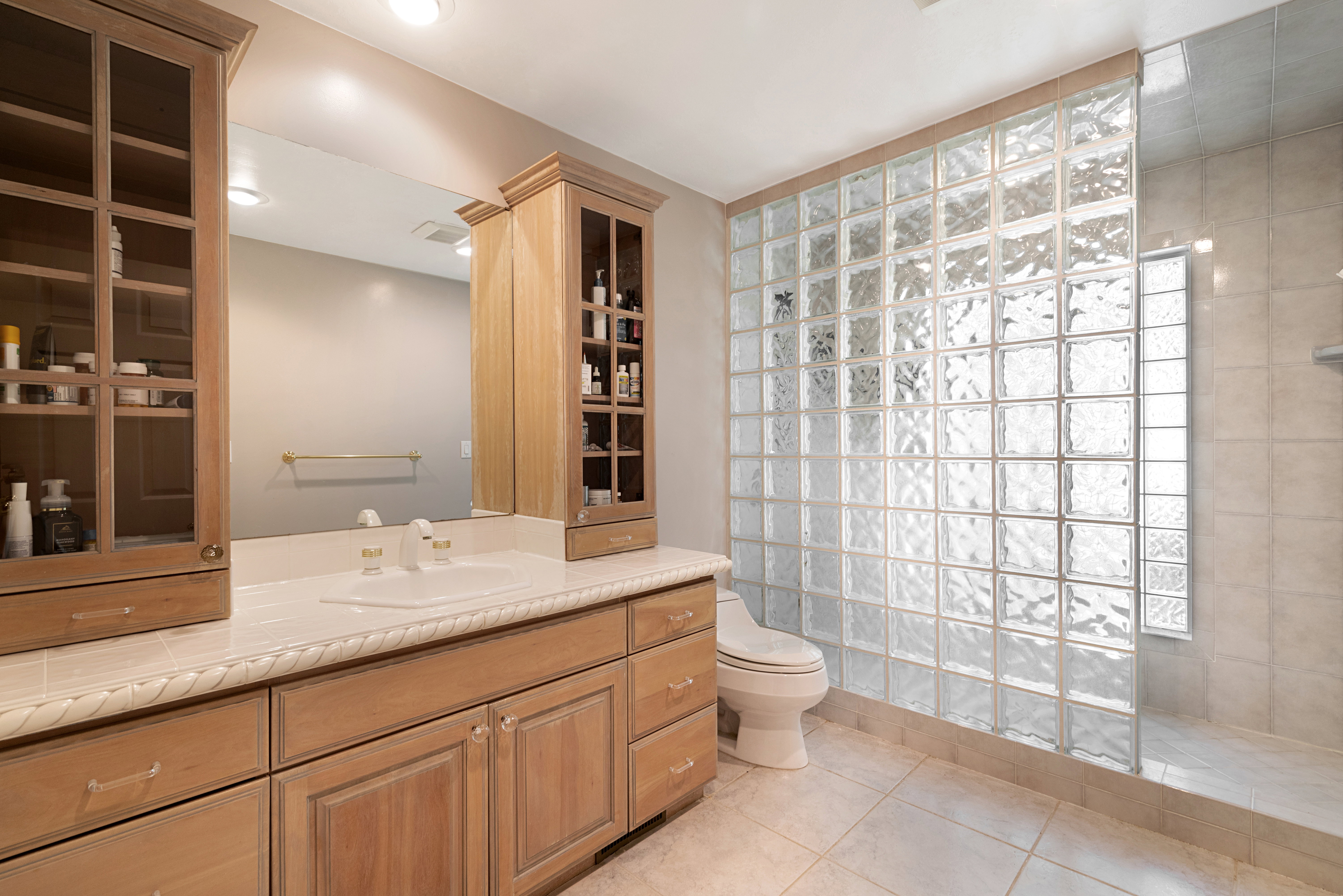 Full bath with a walk in shower, light tile patterned floors, and vanity