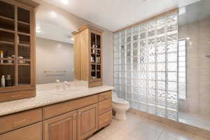 Full bath with a walk in shower, light tile patterned floors, and vanity