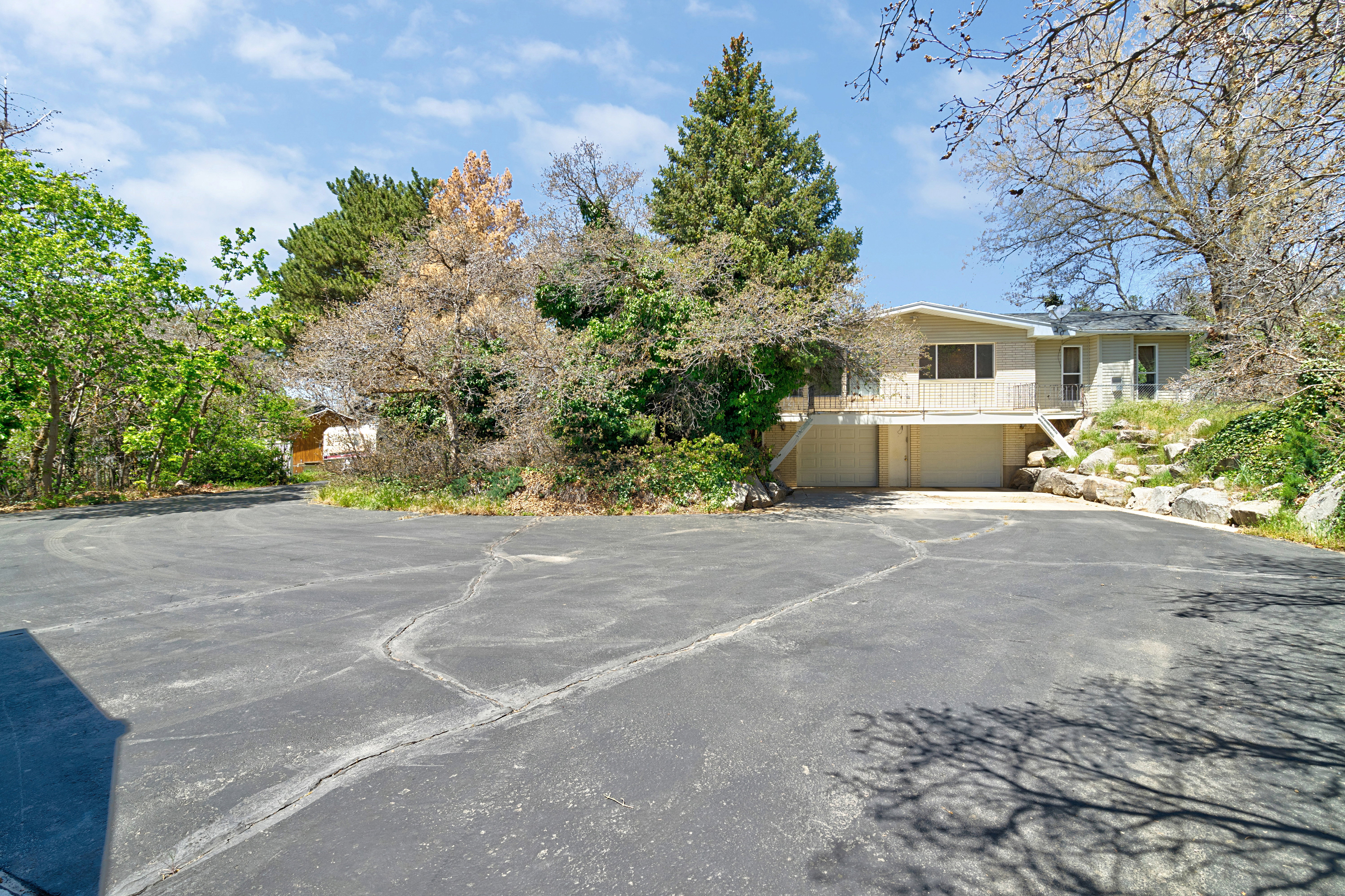 View of parking featuring an attached garage and asphalt driveway