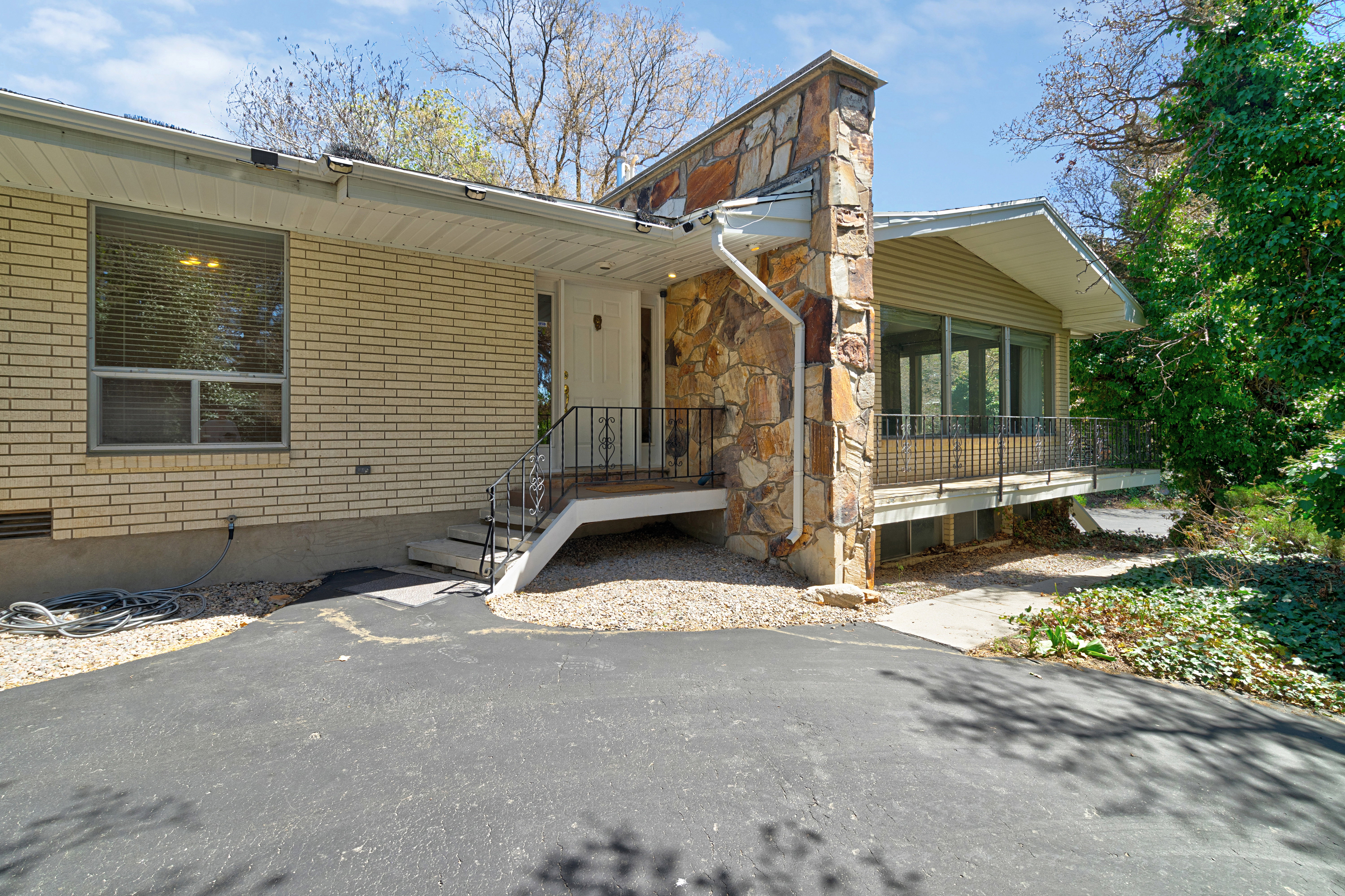 Property entrance with brick siding and a sunroom