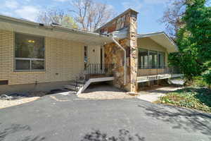 Property entrance with brick siding and a sunroom