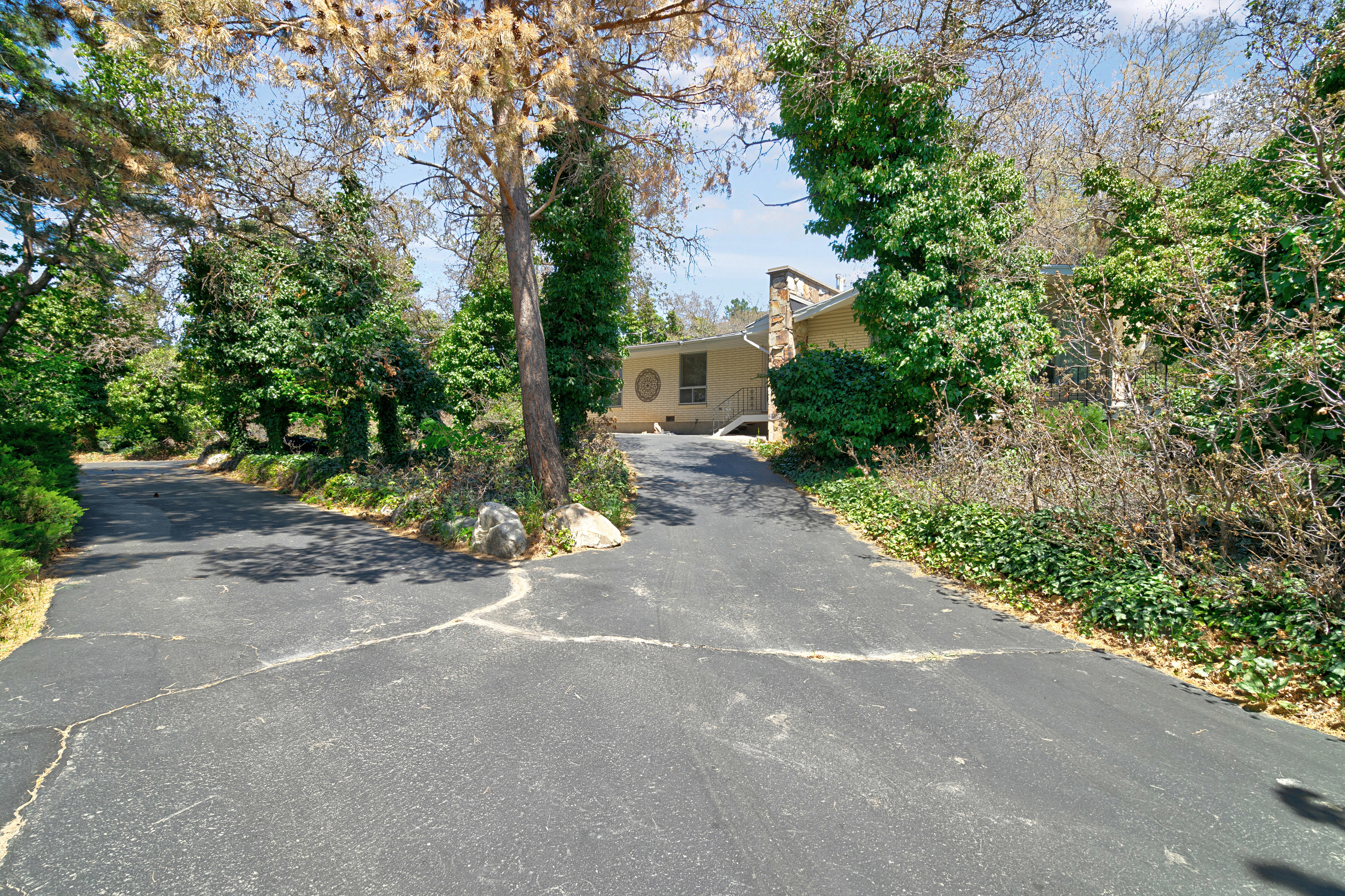 View of front of house featuring a chimney and asphalt driveway