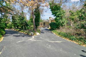 View of front of house featuring a chimney and asphalt driveway