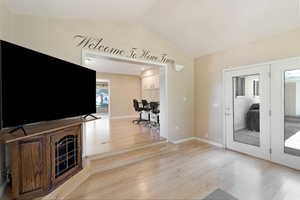 Unfurnished living room with light wood-style flooring and an office area