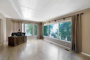 Office featuring light wood finished floors and a textured ceiling