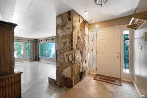Foyer with light stone finish floors and a textured ceiling
