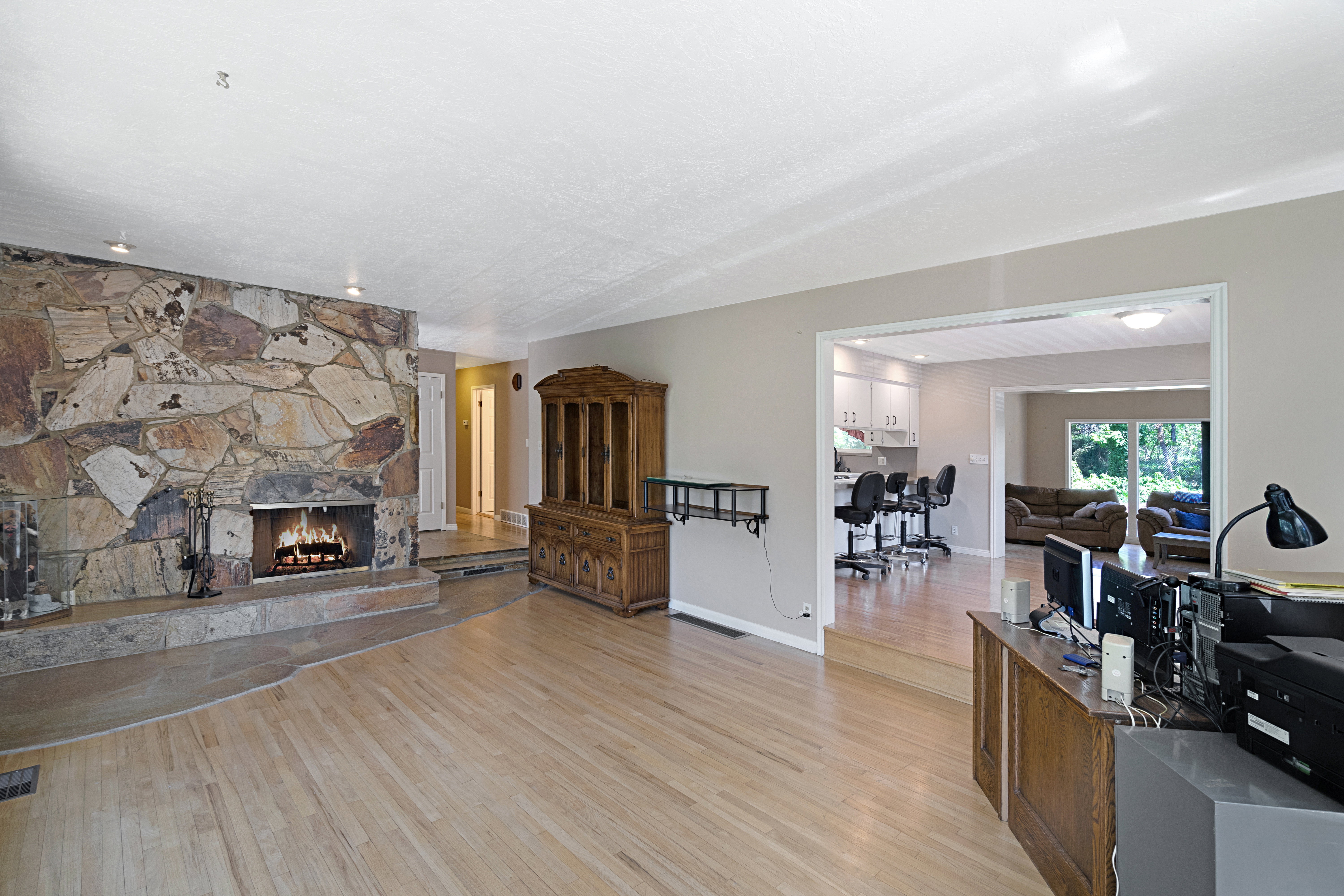 Living area featuring light wood-style flooring and a stone fireplace