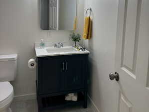 Bathroom featuring a dark wood vanity with a white countertop, undermount sink, and chrome faucet
