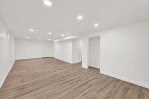 Finished below grade area featuring recessed lighting and light wood-style flooring