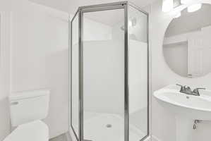 Full bath with toilet and a shower stall