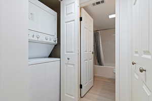 Stacked laundry appliances within a dedicated closet, featuring white panel doors