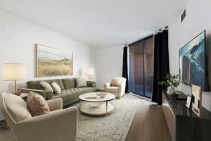 Living area featuring light wood-finish flooring, white walls, and a large sliding glass door