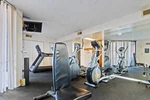 Fitness room featuring rubber flooring and mirrored walls