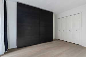 Light wood-finish flooring complements the white walls and textured ceiling
