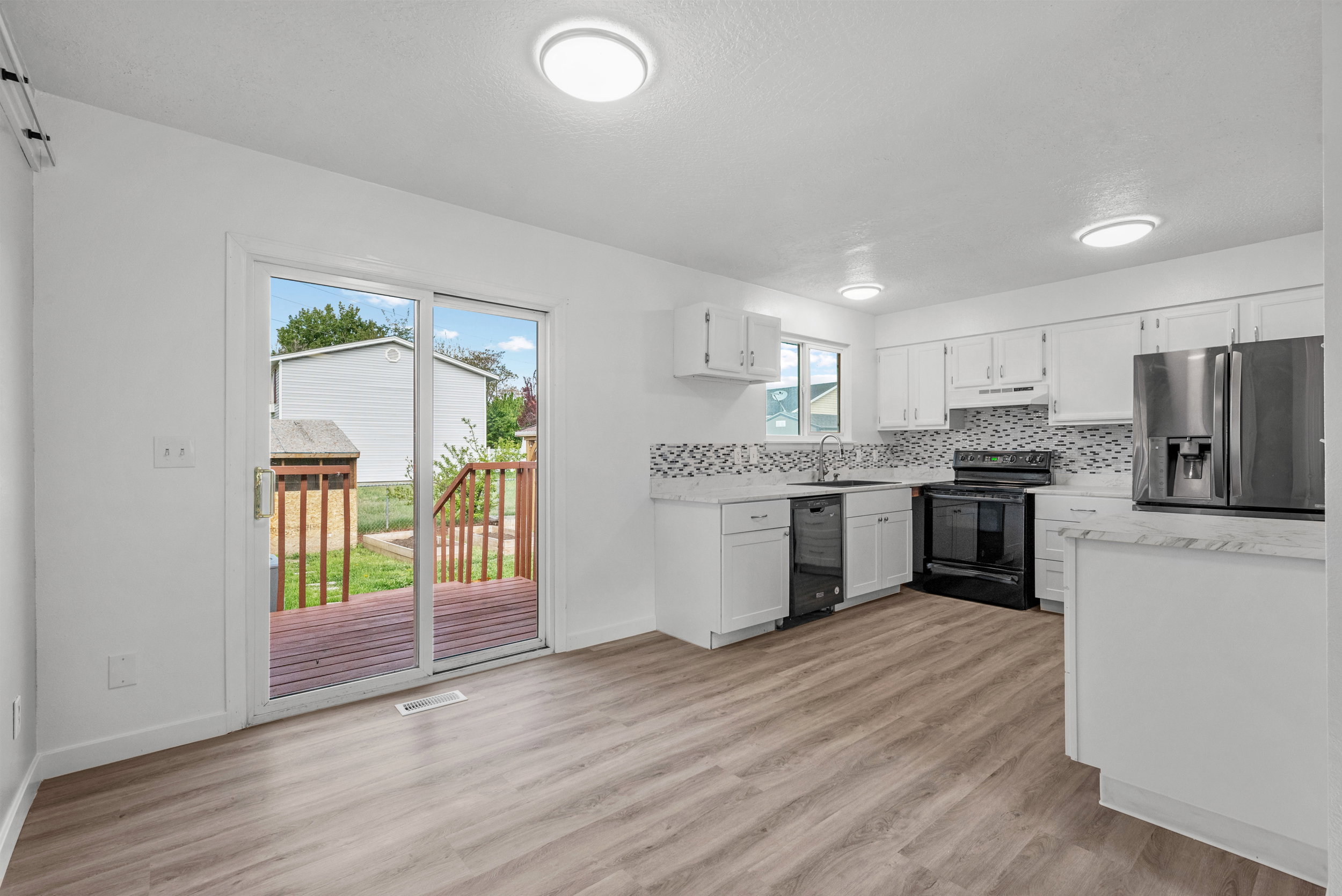 Open-concept kitchen featuring white cabinetry and light-toned countertops