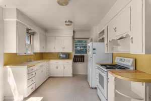 Kitchen featuring white cabinetry with contrasting yellow countertops and backsplash