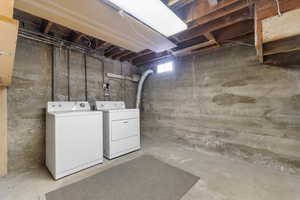 Laundry area with concrete walls and exposed wood ceiling joists