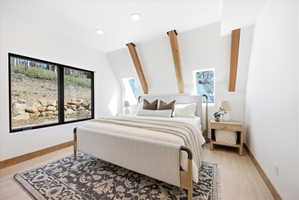 Contemporary bedroom featuring a large picture window, a pair of skylight windows, exposed wooden beams, recessed lighting, and light wood-finish flooring