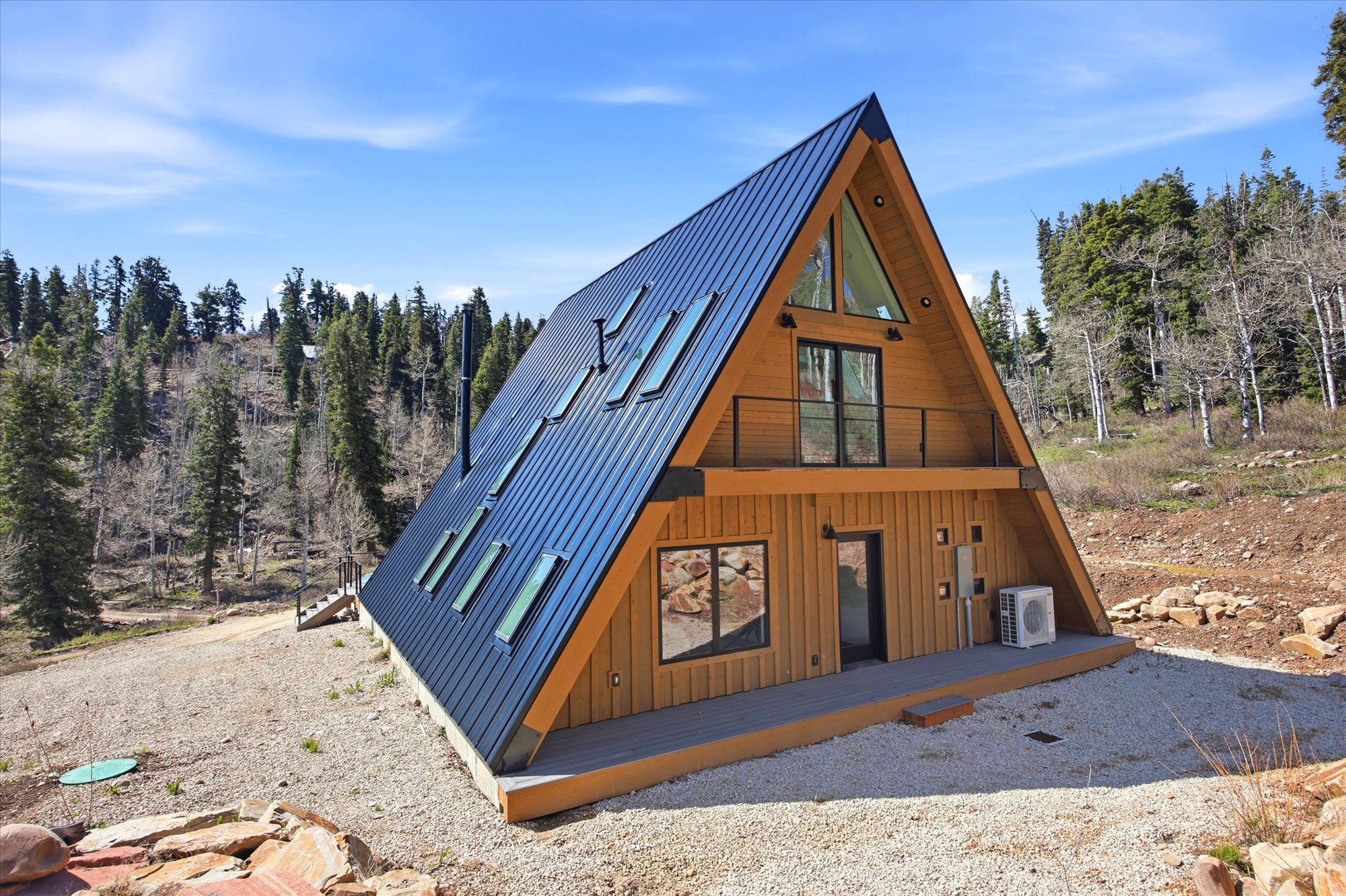 A-frame architectural design featuring natural wood siding and a dark metal roof