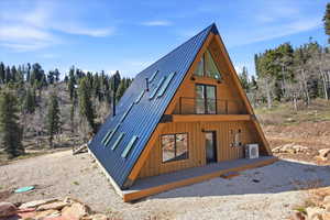 A-frame architectural design featuring natural wood siding and a dark metal roof