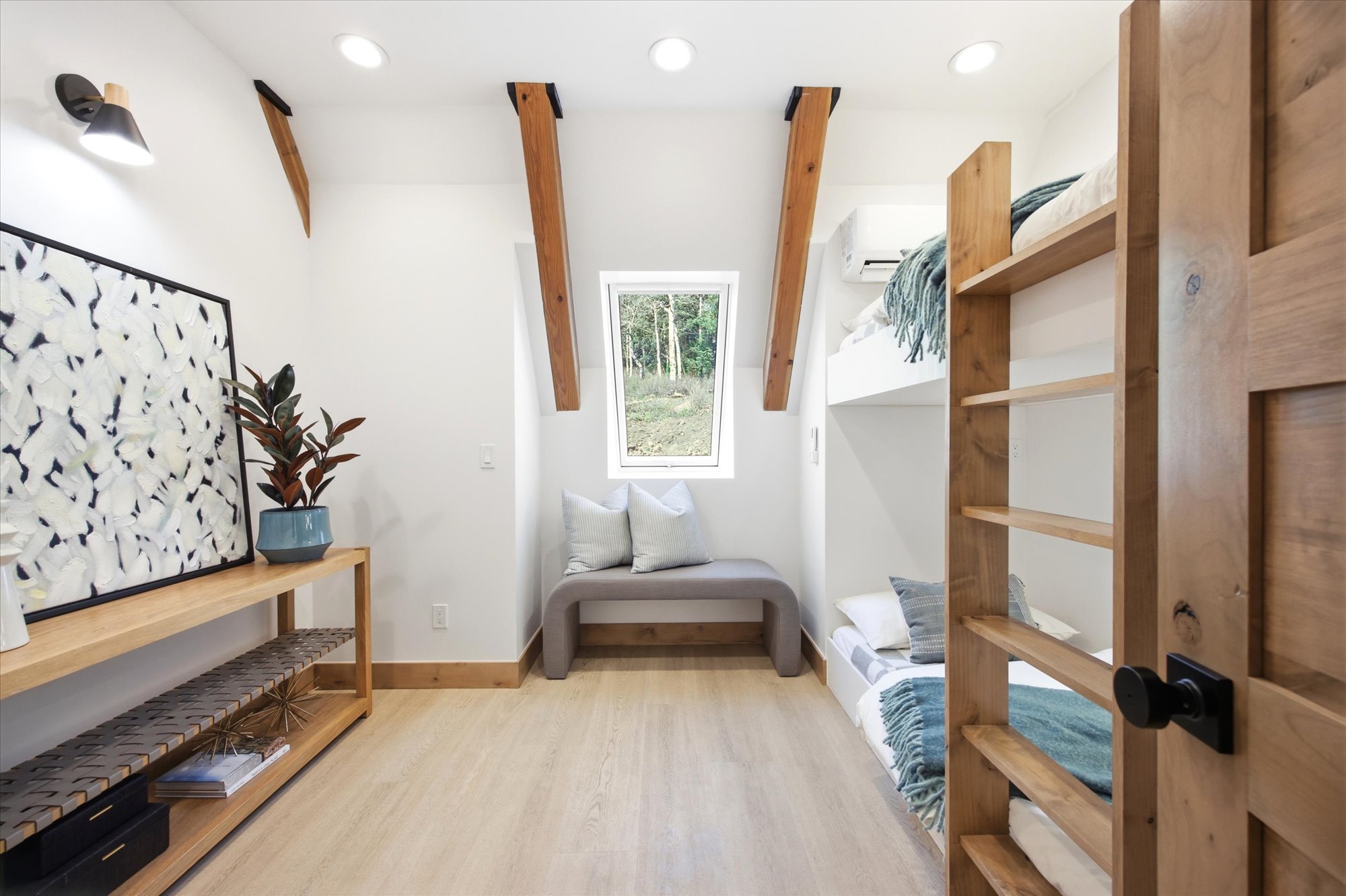Room featuring built-in bunk beds, light wood-finish flooring, and white walls