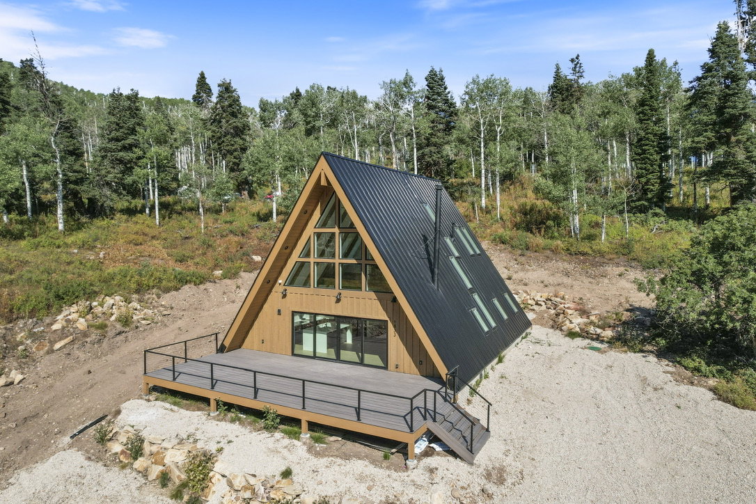 A-frame architecture featuring a dark metal roof and light wood siding