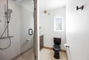 Walk-in shower with clear glass enclosure and matte black fixtures