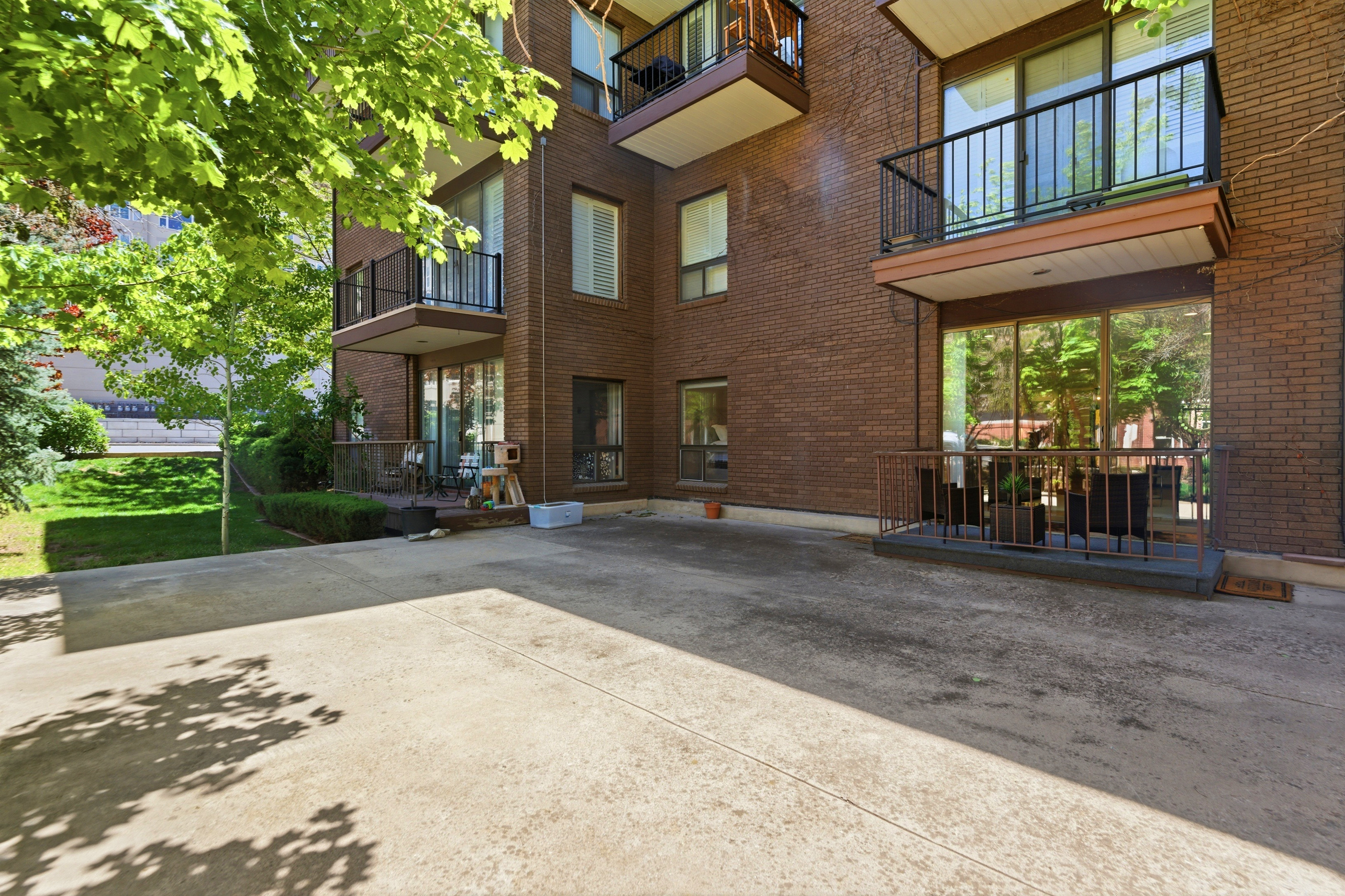 Brick exterior building with multiple private balconies and a ground-level patio